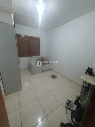 Interior de um cômodo com piso de cerâmica e armário de madeira.