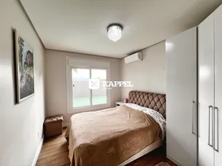 Quarto com cama e armário branco em ambiente interno.