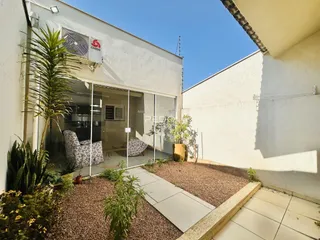Fachada de uma residência com jardim e área externa.