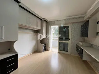 Interior de uma sala de estar com armários e piso de madeira clara.