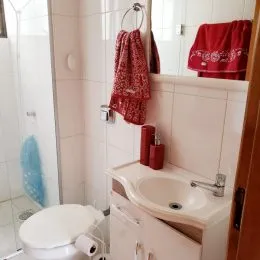 Foto de um banheiro com revestimento de azulejos brancos e pia.