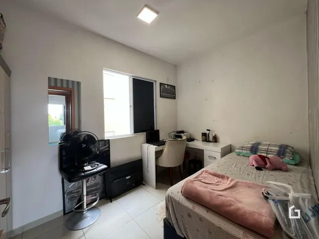 Quarto com cama e escrivaninha em um apartamento.