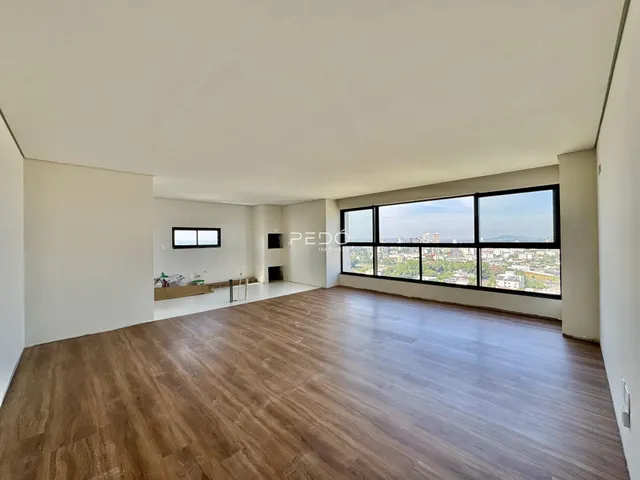 Sala de estar ampla com piso de madeira e vista panorâmica da cidade.
