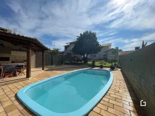 Piscina externa com deck de tijolos em uma residência.