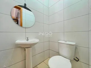 Foto de um banheiro com azulejos brancos e louças sanitárias.