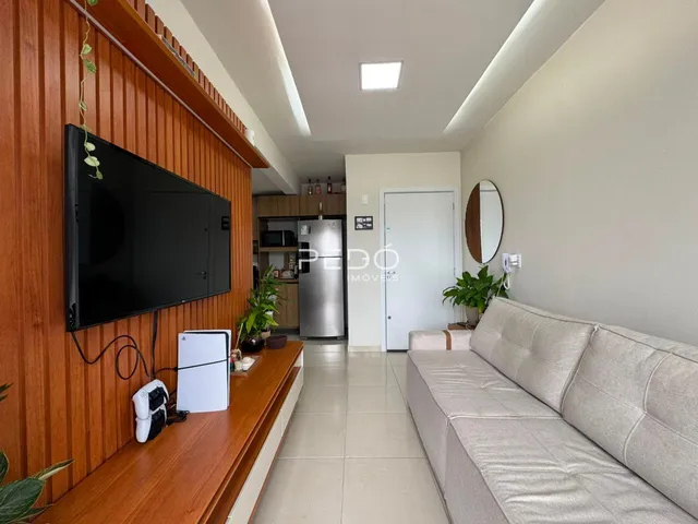 Sala de estar com painel de madeira e sofá claro.
