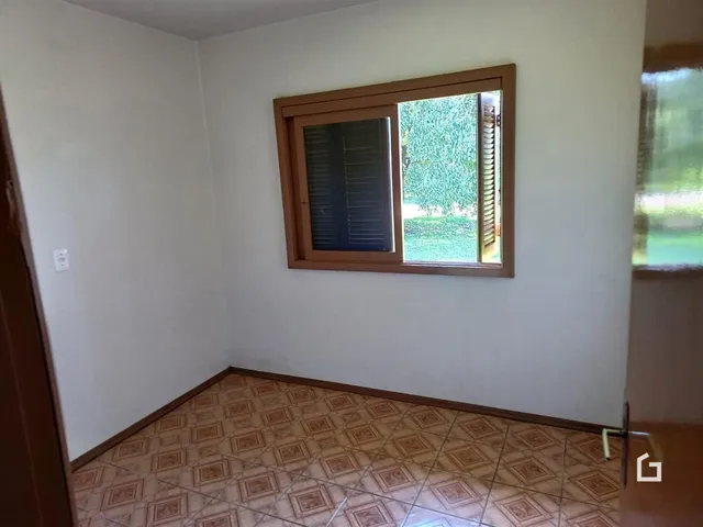Interior de uma sala com piso de cerâmica e janela.