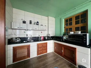 Cozinha com armários de madeira e revestimento branco.