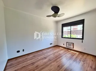 Uma sala de estar com piso de madeira clara.