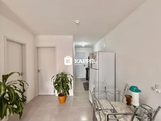 Hall de entrada com paredes brancas e piso de cerâmica.