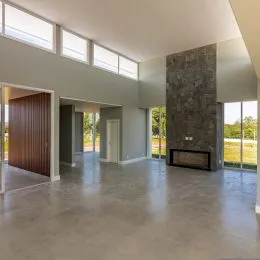 Ambiente interno amplo com piso de concreto aparente.
