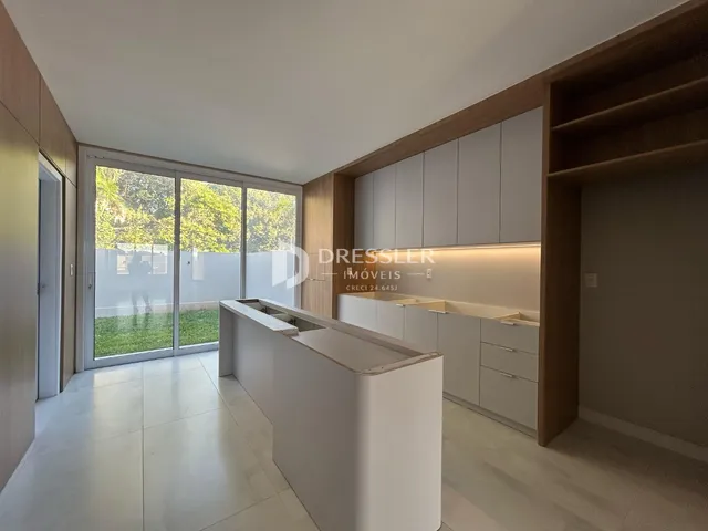 Cozinha moderna com portas de vidro que dão acesso a um jardim externo.