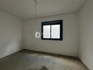 Foto de um cômodo vazio com paredes brancas e piso de concreto cru.