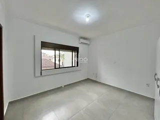 Ambiente interno de uma sala com piso de cerâmica e janela.