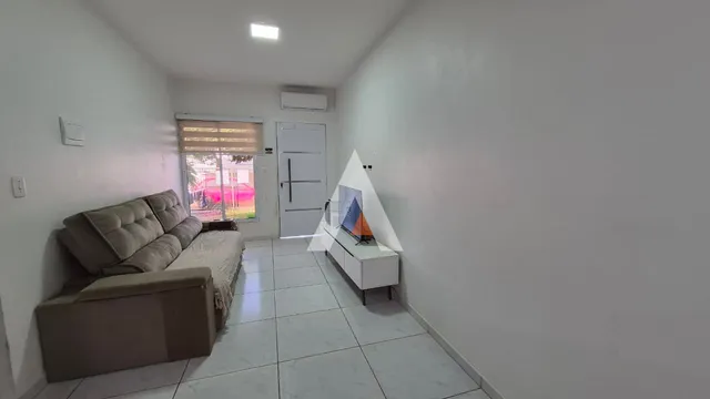 Sala de estar com sofá e piso de cerâmica clara.
