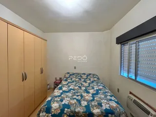 Quarto com armários de madeira e janela.