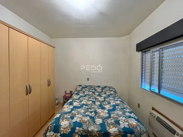 Quarto com armários de madeira e janela.