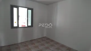 Vista interna de um cômodo com janela e piso de cerâmica.