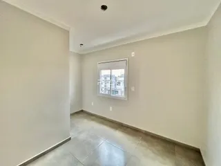 Corredor interno de um imóvel em Lajeado, Brasil, com piso de cerâmica claro.