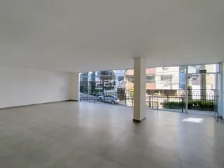 Vista interna de um ambiente com piso de cerâmica e grande janela de vidro.