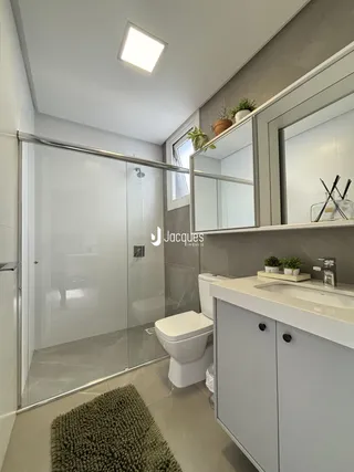 Foto de um banheiro moderno com box de vidro e bancada clara.