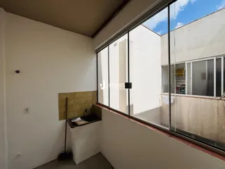 Vista interna de uma área com revestimento de azulejo e janela.