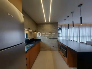 Vista de uma cozinha moderna com armários de madeira e iluminação em Lajeado.