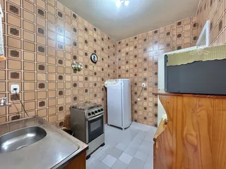 Foto de uma cozinha com revestimento de azulejos marrons e piso claro.