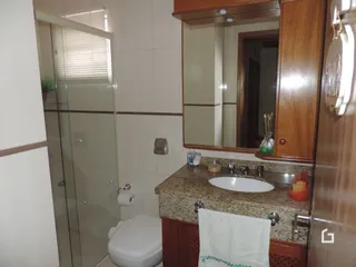 Foto de um banheiro com box de vidro e pia
