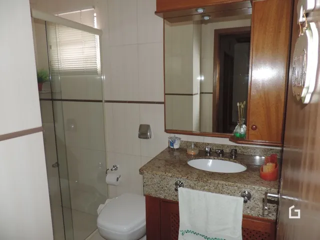 Foto de um banheiro com box de vidro e pia