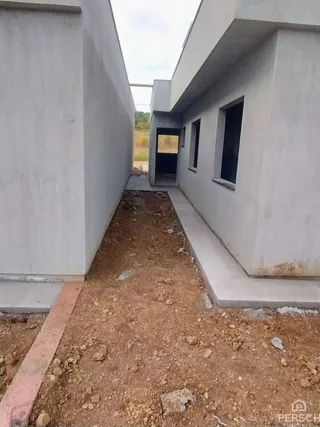 Vista externa de um corredor entre duas paredes brancas de um imóvel em Lajeado.