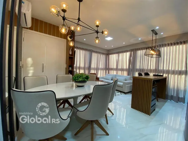 A sala de jantar apresenta uma mesa branca com cadeiras modernas e iluminação decorativa.
