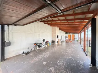 Interior de um espaço aberto com teto de madeira exposta e piso de concreto.