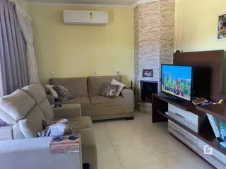 Sala de estar com sofá e televisão em um imóvel.
