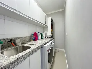 Uma cozinha com bancada de granito e armários brancos.