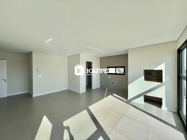 Ambiente interno amplo com piso de porcelanato claro e paredes brancas.