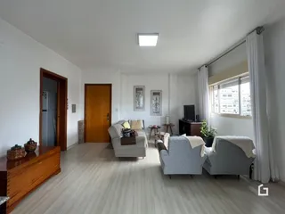 Sala de estar com piso de madeira clara e móveis de sala.