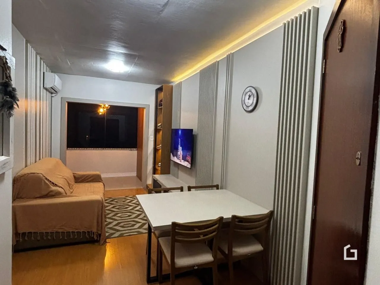 Sala de estar com sofá e mesa de jantar em um imóvel no Brasil.