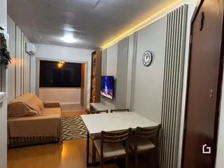 Sala de estar com sofá e mesa de jantar em um imóvel no Brasil.