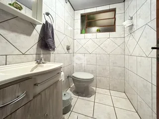 Foto de um banheiro com revestimento de azulejos brancos.