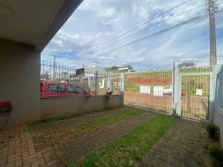Vista da fachada de uma propriedade em Lajeado, Brasil, com cerca e portão.
