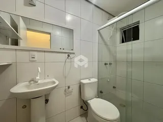 Foto de um banheiro com revestimento branco e box de vidro.