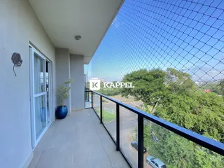 Varanda com vista panorâmica para a paisagem urbana e vegetação.