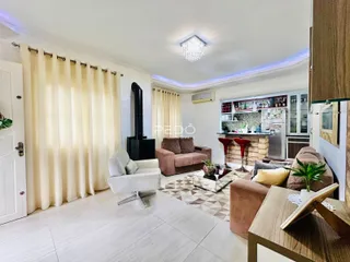 Sala de estar com decoração moderna e grandes janelas.