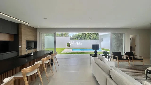 Sala de estar com vista para a piscina e jardim.