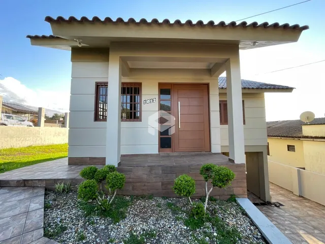 Fachada de uma residência em Lajeado, Brasil, com porta de madeira e área de entrada coberta.
