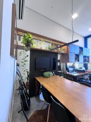 Foto de um ambiente com mesa de jantar de madeira e televisão.