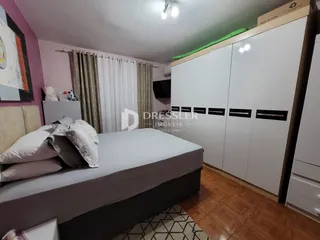 Quarto com cama e armário branco em um imóvel no Brasil.