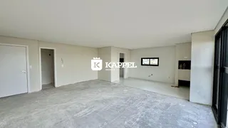 Vista interna de um ambiente amplo com piso de concreto e paredes brancas.