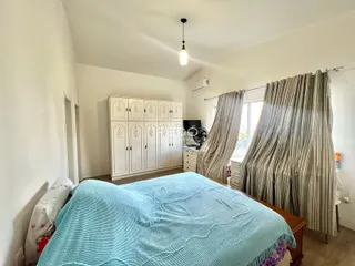 Quarto com cama e armários brancos.